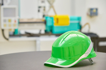 Green safety helmet on industrial backgroundの写真素材