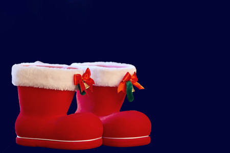 Red Christmas boot with white border and small bells cut out on navy blue background