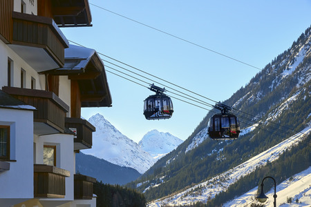Ischgl, Austria - December 24, 2017: Modern aerial tramway in the Austrian Alps ski resort. Highland cable car leads between hills from village to ski slope. Cable car station in Ischgl city center. View from the city.のeditorial素材