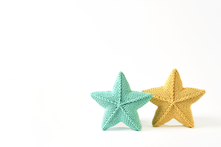 Yellow and blue-green knitted five-pointed star shaped pillows on white background - two pieces - mock up patternの写真素材