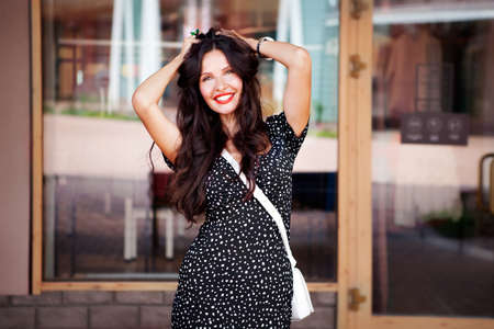 Portrait beautiful young woman smiling near shop window. Happy Model dark long hair with pretty smileの写真素材
