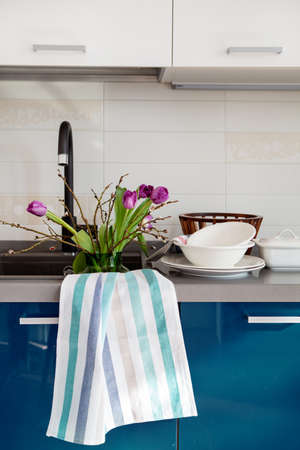 Bouquet of flowers tulips are watered in sink in kitchenの写真素材