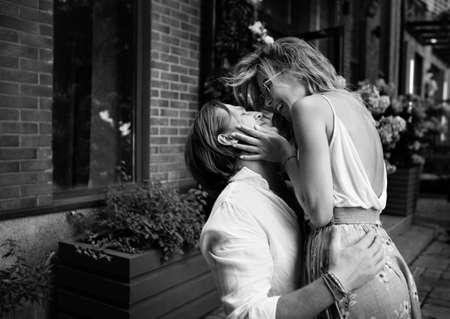 Young beautiful Sensual couple laughing, having fun on the street. Happy man and woman in love embrace. Black and white photo of Caucasian hugging modelsの写真素材