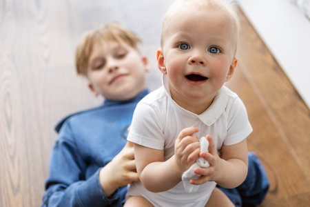 Brother holding baby. Young boy holding little baby. Family bond concept. Happy childhood and family...