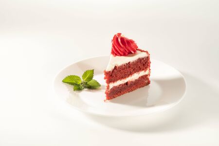 piece of cake Red velvet on a white background. Mint leaf as a decoration.の写真素材