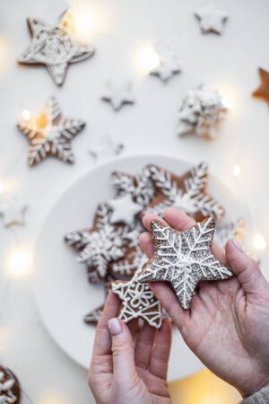 cookies with ginger painted with white icing on a white background and Christmas garlands