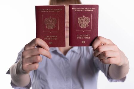 woman holds two passports of the Russian Federation on a white backgroundの写真素材