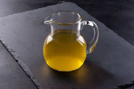 glass jug with olive oil on a black backgroundの写真素材