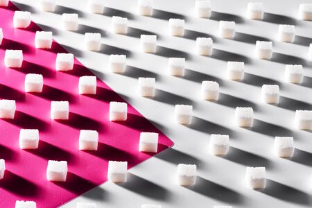 on a white and pink background sugar cubes are staggeredの写真素材
