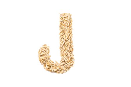 Letter of the English alphabet - J, laid out from oats seeds on a white backgroundの写真素材