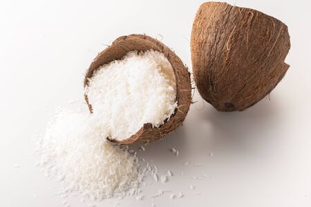 coconut flakes lies in a coconut shell, cut into two halvesの写真素材