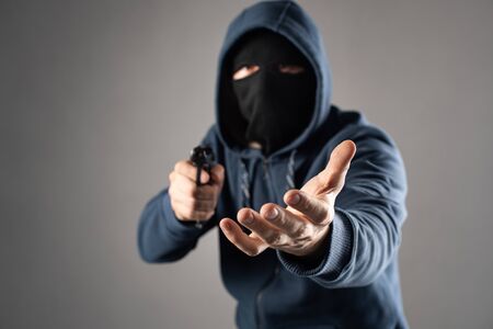 male criminal with a gun extorts moneyの写真素材