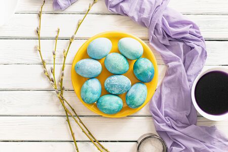 marble Easter eggs painted with natural colors, cabbage red juice and salt. Near willow branches and a lilac towelの写真素材