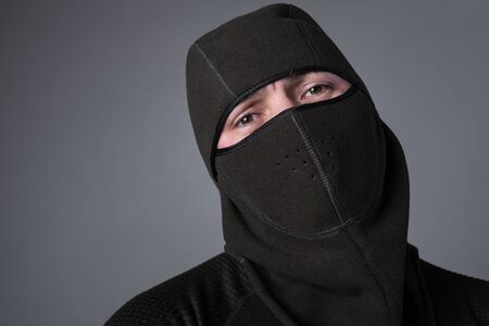 A man in a balaclava, as a concept of special forces or a criminal, stands with a menacing lookの写真素材