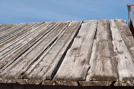 old wooden roof of a barn in the countryside against the skyの写真素材