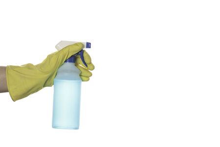 A hand in a yellow glove holds a plastic bottle with a dispenser with blue liquid for cleaning surfaces.の写真素材