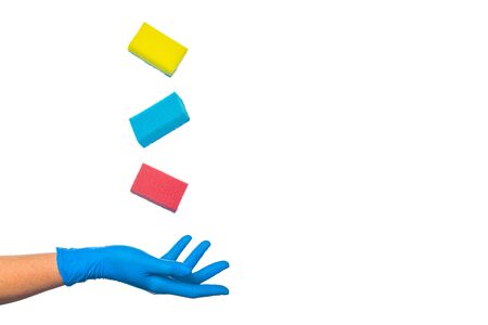 hand in a protective glove throws up multi-colored cleaning sponges on a white background