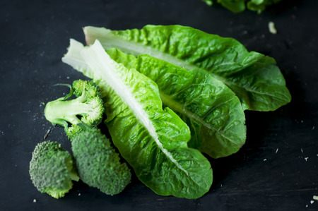 Fresh green Cos lettuce and broccoli on dark background.の写真素材