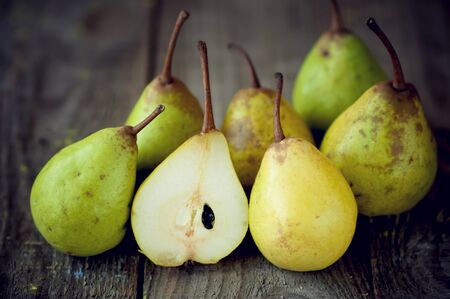 fresh pears lie sliced in half on a wooden table