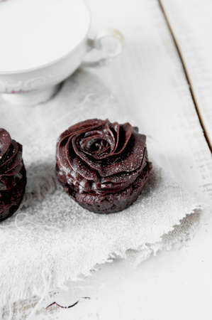 Chocolate muffins decorated with cream in the form of rosesの写真素材