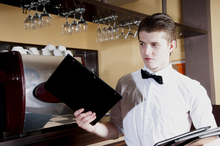 Handsome bartender in uniform with menu.の写真素材