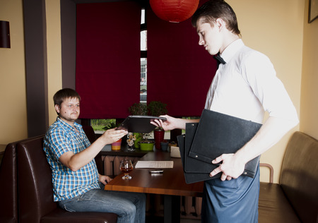 Man makes an order  to the waiter at a restaurant.の写真素材