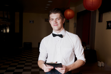 Handsome bartender in uniform with menu.の写真素材