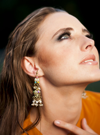Glamorous woman  with makeup  looking up , wearing long earrings.の写真素材