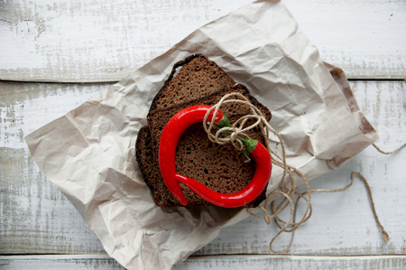 Slices of rye bread with chili pepper  on wooden boards.の写真素材
