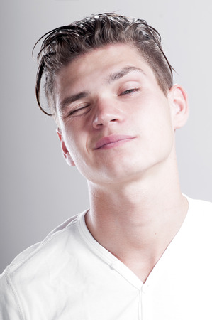 Close-up portrait of cheerful young man grimacing.の写真素材