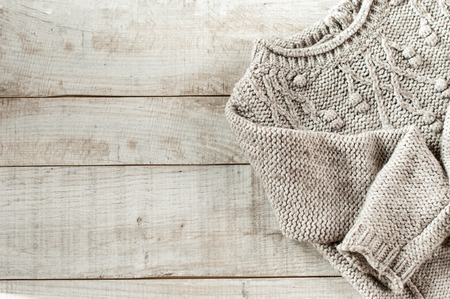 knitted pullover on wooden boards with copy space for text.
