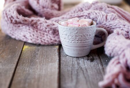 coffee mug with marshmallows in front of a knitted scarf, flat layの写真素材