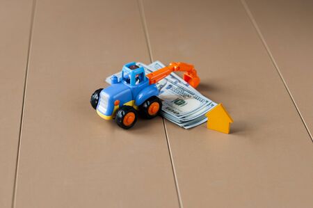 Toy excavator rakes dollars.の写真素材