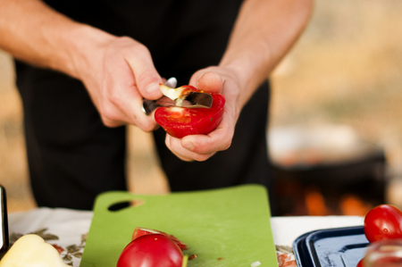 man's hands cut tomato outdoorの写真素材