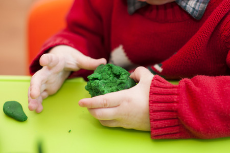 child holding a green clayの写真素材