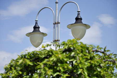 A lamppost in the garden against a blue sky background