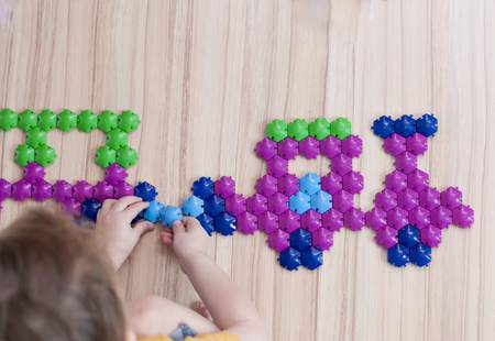 the child collects a locomotive from a multi-colored hexagon mosaic on floor.の写真素材