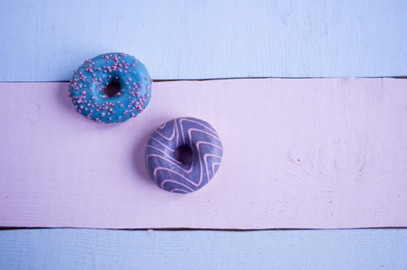 donuts with blue and violet glaze flat lay on different boards.の写真素材