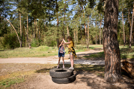 Two little girls playing in a pine forest