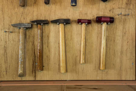 different hammers on the brown wooden background