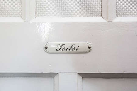 vintage toilet sign with the words toilet on a white wooden door publicの写真素材