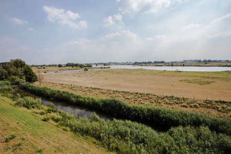 Landscape with water canal in the Netherlands Colorful blue sky with clouds. Spring landscape in...