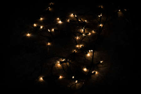Christmas lights on dark stone black backgroundの写真素材