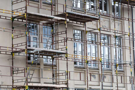 Tall building under construction with scaffolds closeup