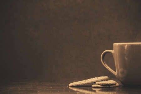 Closeup of chocolate cookies and a cup of coffee. Symbolic image. Concept for a tasty snack. Sweet dessert. Selective focus. background textureの写真素材