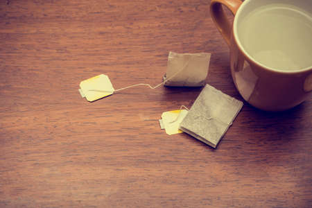 Cup of tea with tea bags on brown table background textureの写真素材