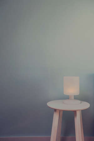 Lamp night light on wood table with blue wall for text space. Vintage effect style picture. Minimal concept. background textureの写真素材