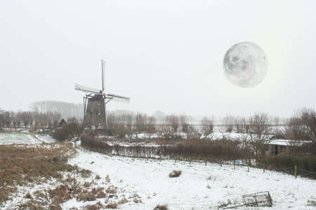 Beautiful Dutch winter windmill landscape with full moonの写真素材