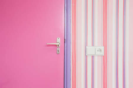 pink door with pink striped wallpaper closeup, girly design interiorの写真素材