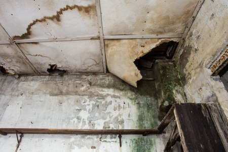 Damaged ceiling from water leak in old abandoned houseの写真素材